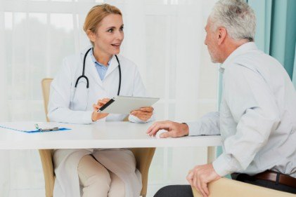 doctor-talking-patient-while-holding-tablet